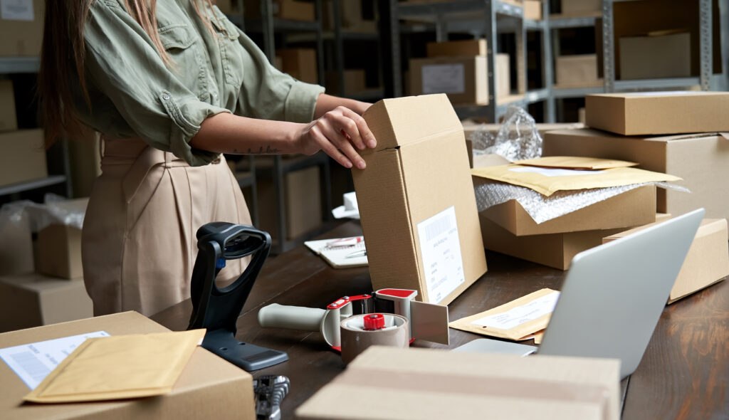 Female small business owner packing ecommerce order