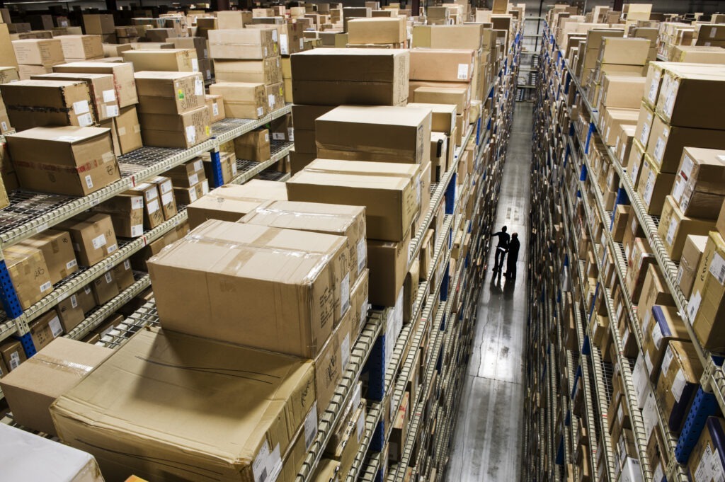 Looking down and over racks of products stored in boxes in a distribution warehouse.