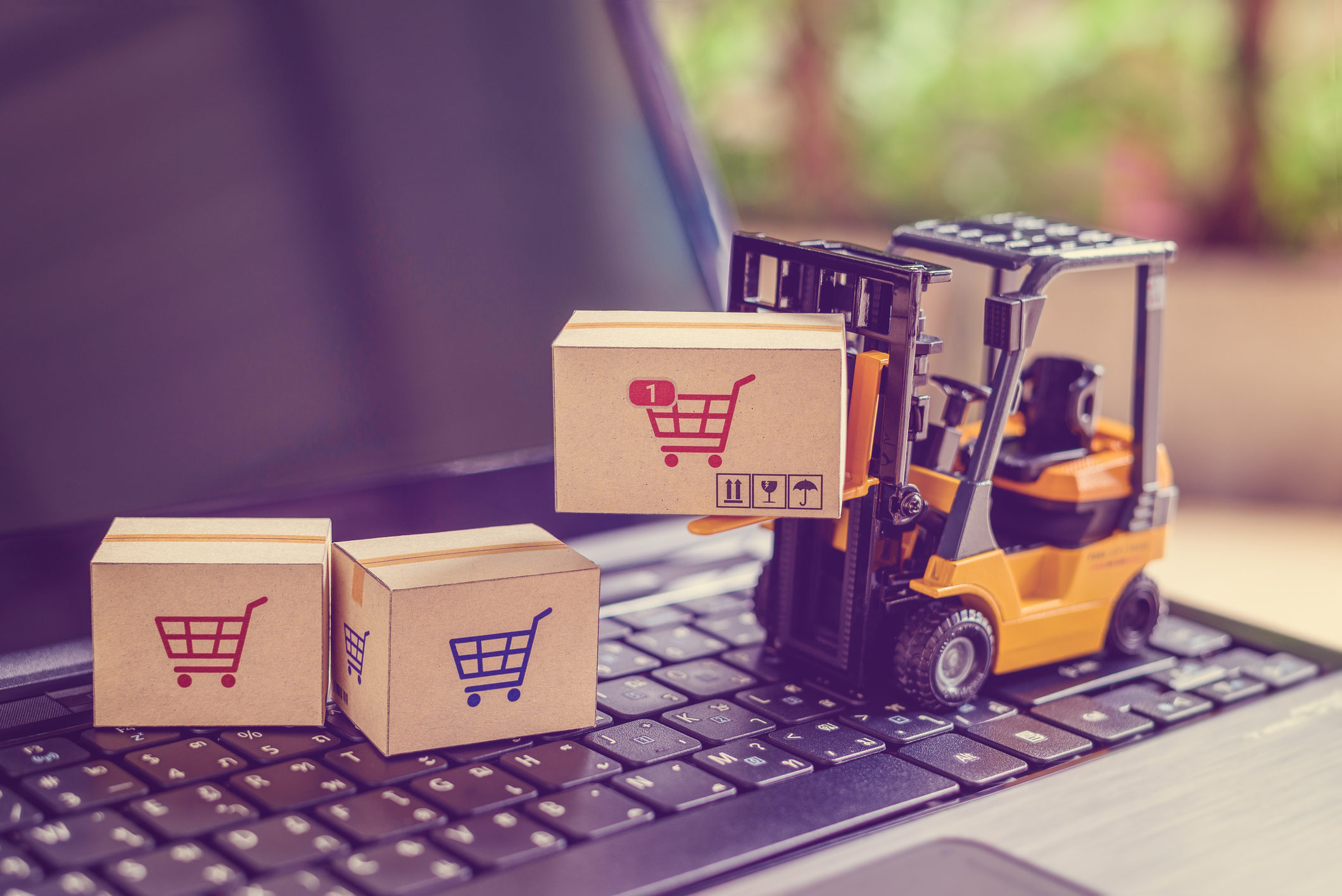 toy forklift with packages on top of laptop
