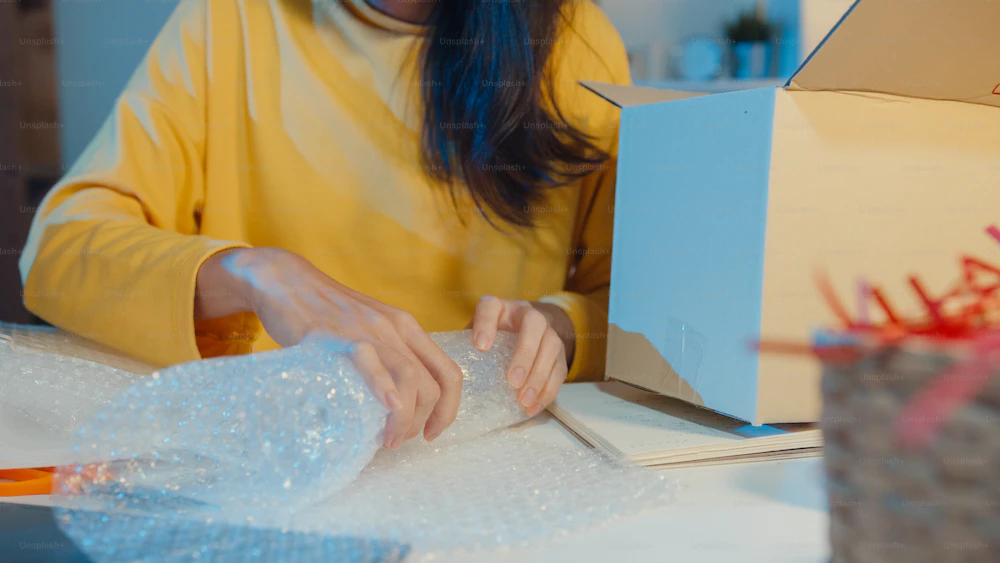 woman wrapping product in bubble wrap