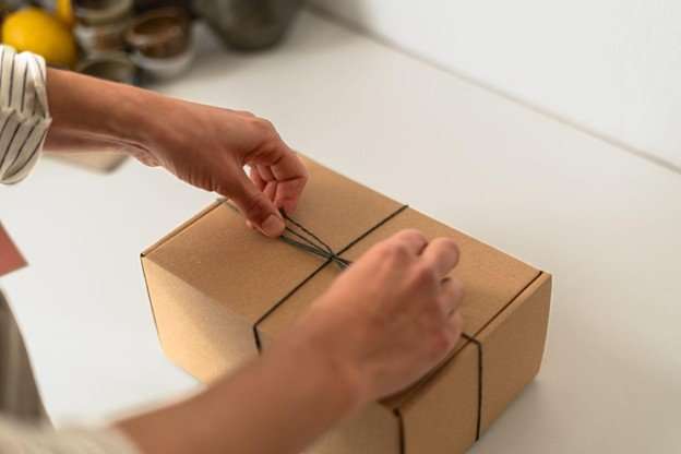 small parcel being tied on table displaying jewelry fulfillment